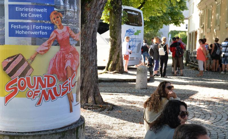 A muzsika hangja egy jelenetét ábrázoló plakát és turisták salzburgi Mirabell téren 2014. augusztus 1-jén