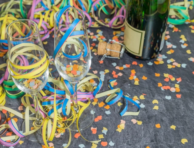 Pezsgős pohár, pezsgős üveg, szilveszteri buli hangulat szerpentinnel, konfettivel