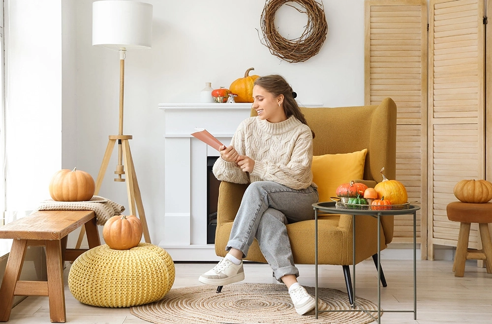 Nő ül a kanapén magazinnal a kezében #ősz #lakberendezés #cozy home