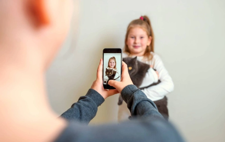 Anyuka fotózza kislányát a telefonnal